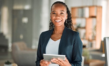 Smiling woman holding tablet in office