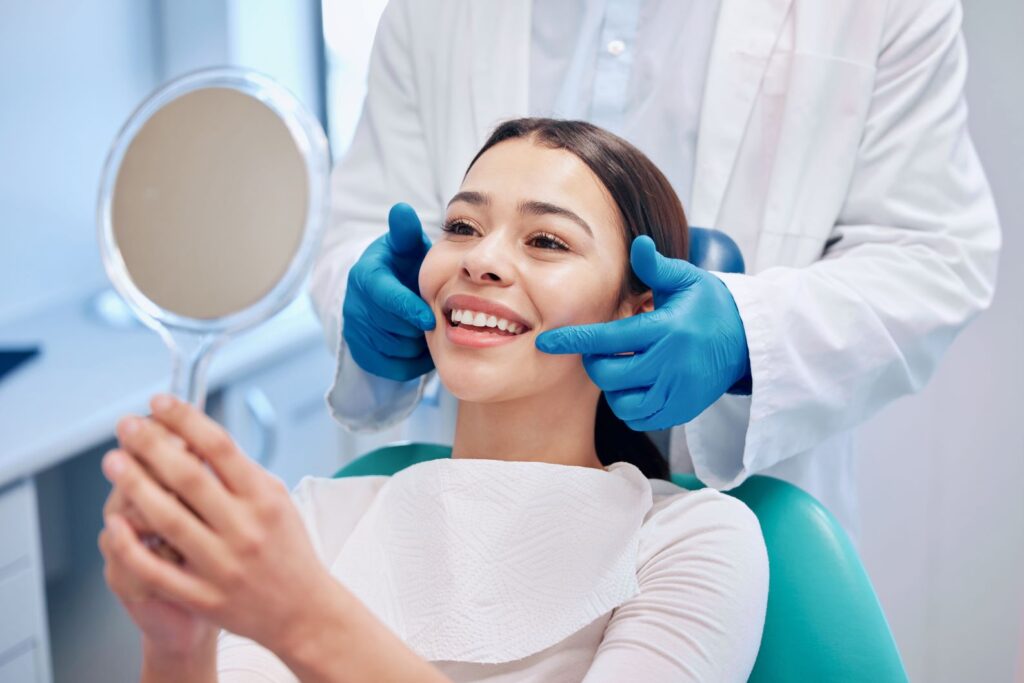 A woman looking in the mirror at the dentist