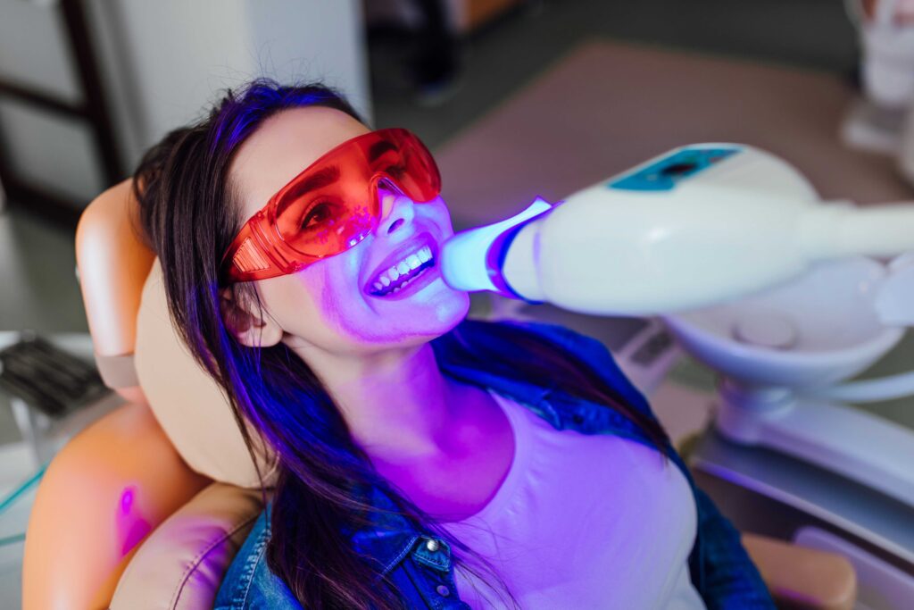 Woman whitening her teeth